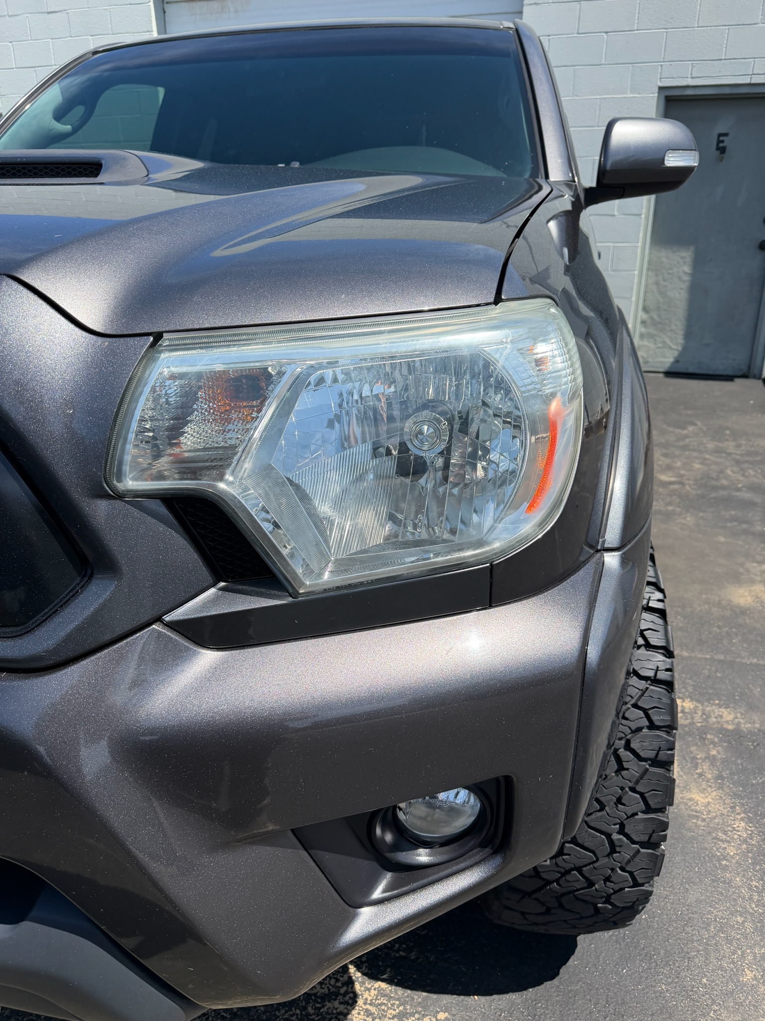 Same Toyota Tacoma headlight lens fully clear after professional restoration
