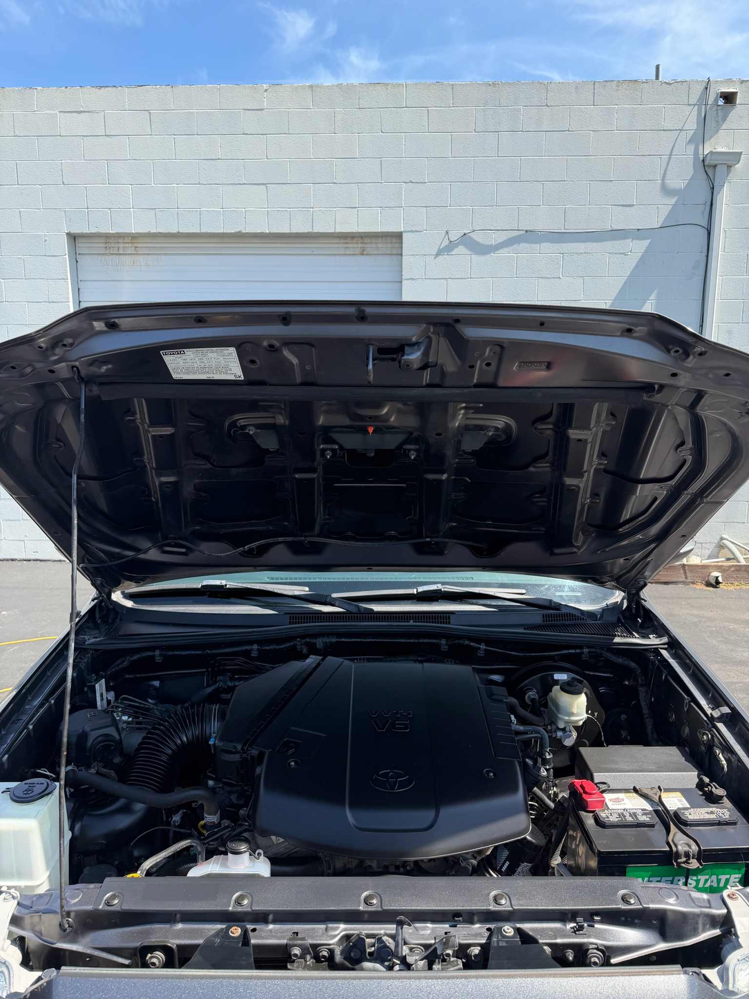 Toyota V8 engine bay mid-cleaning during an engine bay detail