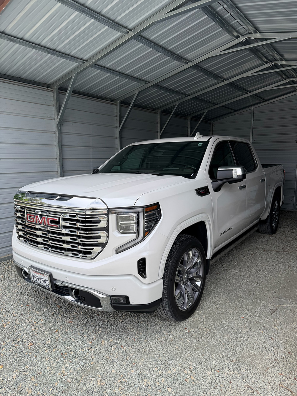 White GMC Sierra Denali after a full detail package in a residential carport